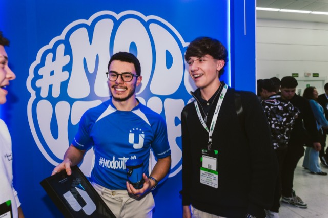 Cliente com a camisa #modoutmify conversando no estande da UTMify